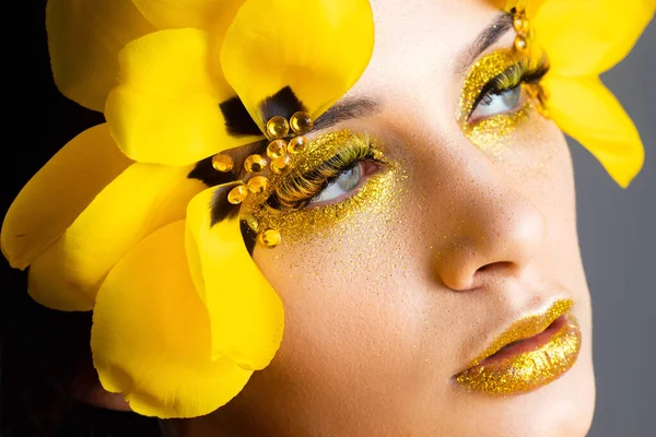 Beauty portrait of a brunette with extended eyelashes in the image of a tulip.