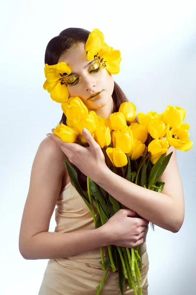 Beauty portrait of a brunette with extended eyelashes in the image of a tulip.