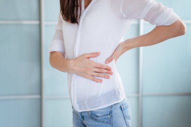 Genç bir kadının evinde sırt ağrısı var.