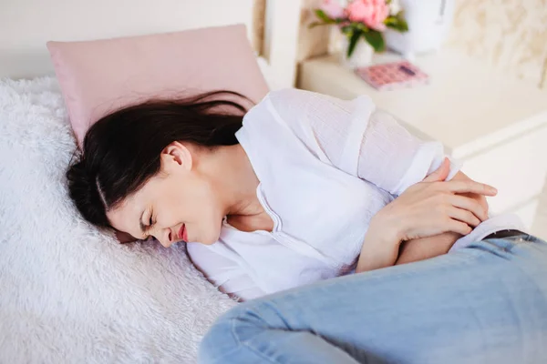 ベッドの上の家の女性は腹痛に苦しんでいる 精神科医 — ストック写真