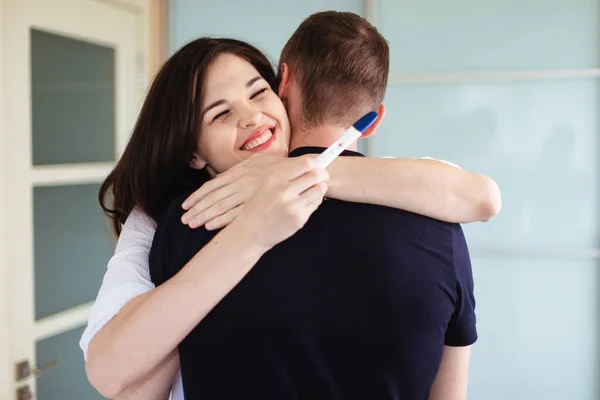 Una Giovane Donna Abbraccia Marito Con Test Gravidanza Positivo Mano — Foto Stock