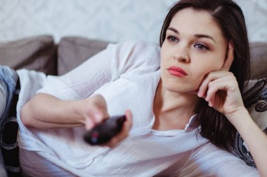 Akşamları televizyon izleyen genç bir kadın.