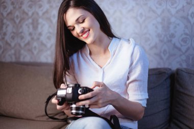 Akşamki çekimlerden sonra genç bir bayan fotoğrafçı kameradaki fotoğrafları inceliyor.