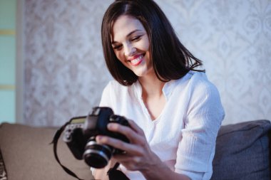 Akşamki çekimlerden sonra genç bir bayan fotoğrafçı kameradaki fotoğrafları inceliyor.