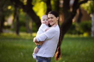 Anne doğanın ellerinde küçük bir oğul tutuyor. Çocukla yürü..