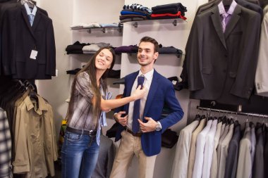 Kız satıcı bir istemcinin bir kravat erkek giyim butik, almak için yardımcı olur