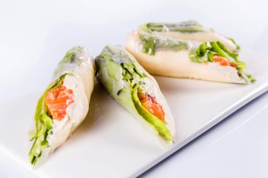 Beyaz arka planda sebzeli pirinç kağıtları ve deniz ürünleri izole edilmiş. Geleneksel Japon mutfağı