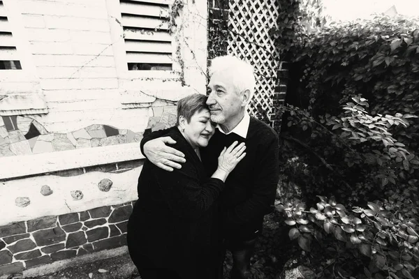 Elderly couple in love walking in the autumn park. Older people hug each other.Black and white photo