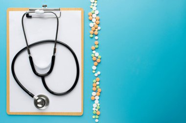 Metin için mavi arkaplan üzerinde pano bulunan steteskop.