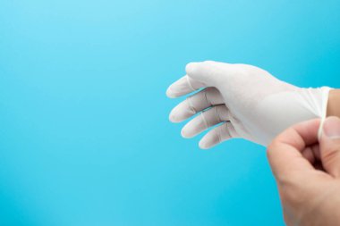 Doktor mavi arkaplanlı ameliyat eldivenlerini metin için kopyalama alanına koydu