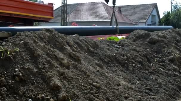 Nahaufnahme langes Rohr klettert in Erdgraben — Stockvideo