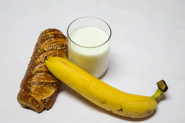 Pastelería, plátano y vaso de leche aislados sobre fondo blanco —  Fotos de Stock