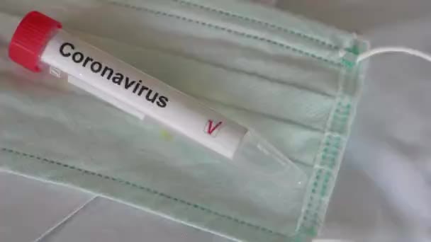 Test del coronavirus. Tubo di prova adagiato sulla maschera respiratoria protettiva ispiratrice. Prova COVID-19 o prova SARS-CoV-2. Smettila di diffonderti — Video Stock