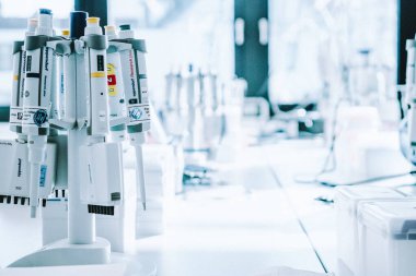 Bulanık laboratuvar arka planı üzerine laboratuvar pipetleri, metin için boş alanı olan araştırma ve geliştirme kavramı.