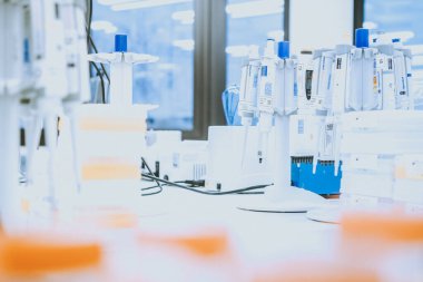 Bulanık laboratuvar arka planı üzerine laboratuvar pipetleri, metin için boş alanı olan araştırma ve geliştirme kavramı.