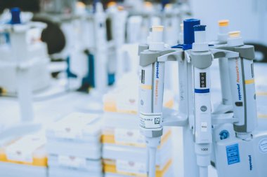 Bulanık laboratuvar arka planı üzerine laboratuvar pipetleri, metin için boş alanı olan araştırma ve geliştirme kavramı.