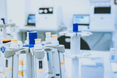 Bulanık laboratuvar arka planı üzerine laboratuvar pipetleri, metin için boş alanı olan araştırma ve geliştirme kavramı.