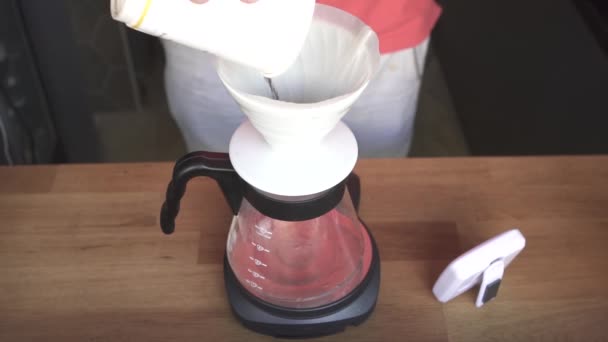 Бариста медленно наливает кипяченую воду в жареный кофе — стоковое видео