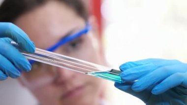 Kadın tıbbi ya da bilimsel araştırmacı veya kadın doktor gözlük ve net çözüm bir laboratuvar bir test tüpünde bakarak lateks eldiven