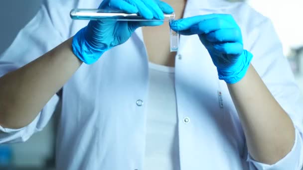 Scientist woman pouring liquid into medical spectro in laboratory or hospital. Sample filling in spectrophotometer cuvettes for analysis, close up — Stock Video