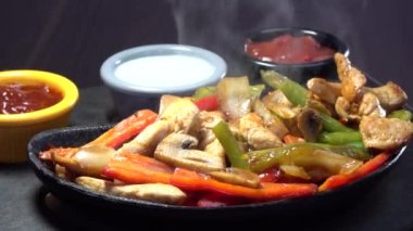 Siyah seramik lav Meksika Fajita guvec plaka sıcak duman Buhar ile döner