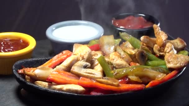 Black seramic lava Mexican Fajita guvec plate rotating with hot smoke steaming — Stock Video