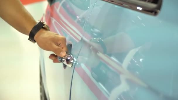 IZMIR, TURKEY, CAR EXHIBITION - OCTOBER, 2016: Handsome man opens door and gets in new Fiat car with blue color. Auto business, car sale, technology and people — Stock Video
