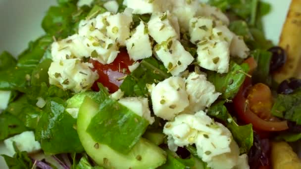 Griekse salade met verse groenten, feta en zwarte olijven. Gezonde verse vegetarische gerechten. Roterende schot. — Stockvideo