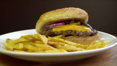 Patates kızartması ile erimiş peynirli burger. Plaka üzerinde döndürme