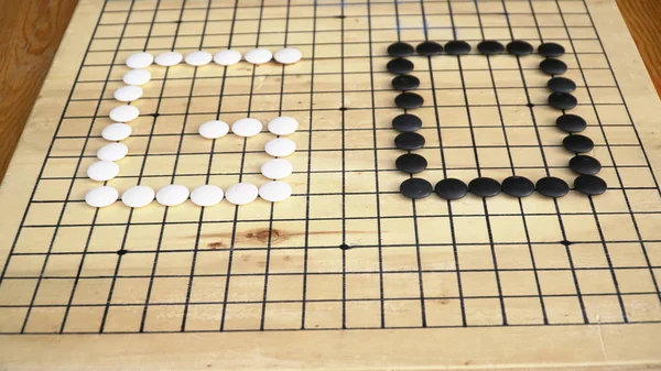 Chinesisches Go oder weiqi Brettspiel. Go-Titel mit schwarzen und weißen Steinen. — Stockfoto