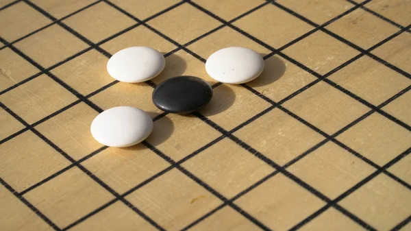 China Go o Weiqi juego de mesa. Ir ttitle con piedras en blanco y negro. Actividad exterior Imagen de stock