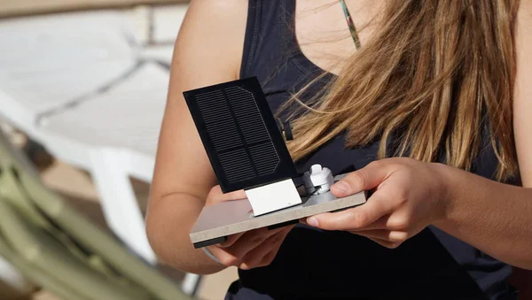 Güneş pili paneli dışında el ile kız öğrenci