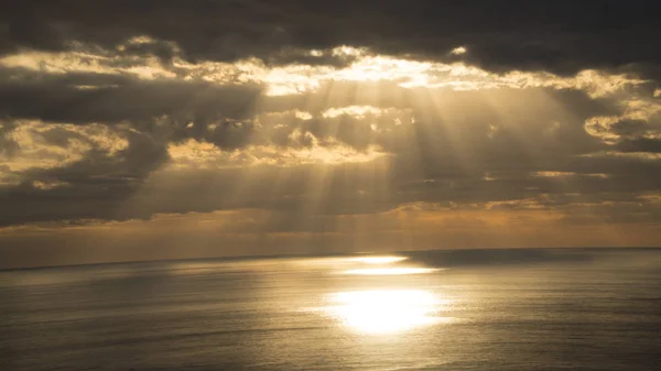 Günbatımı ve güneş ışıkları gelir bulutlar okyanus arasında