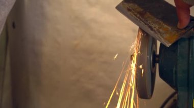 Bir fabrika taşlama demir balta ile metal işçisi kıvılcım