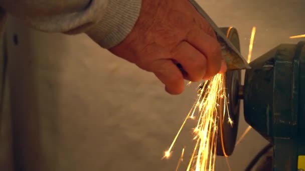 Kovové dělník v továrně broušení Železná sekera s jiskry — Stock video