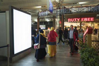 Istanbul Türkiye - Aralık 13 - 2016:Passengers ve dünya seyahat etmek Istanbul Atatürk Havaalanı'nda. Atatürk Havalimanı Türkiye'deki en büyük havaalanıdır. Alay kadar dikey sokak poster Pano havaalanında, boş.