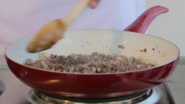 Chef mescolando carne macinata friggendo con cipolle affettate su padella di ceramica . — Video Stock