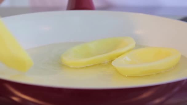 Grandes frites de pommes de terre tranchées dans une poêle en céramique. Huile bouillante. Gros plan . — Video