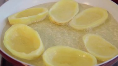 Büyük bir patates cipsi seramik tavada kızartma dilimlenmiş. Kaynayan yağ. Yakın çekim.