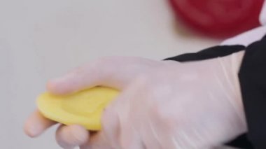 Et ve sebze ile doldurun ve doldurulmuş patates için yağda kızartmak için soyulmuş patates curvely olmak dilimlenmiş. Şef patates beyaz eldivenli keser.