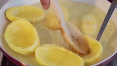 Şef dönüm büyük bir patates cips seramik tavada kızartma dilimlenmiş. Kaynayan yağ. Yakın çekim.