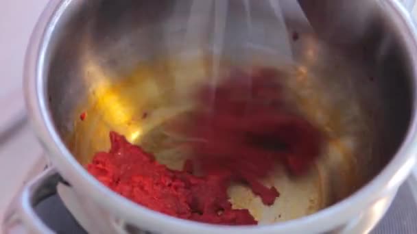 Směšování horké rajčatové omáčce s kovovou lžící na pánvi — Stock video