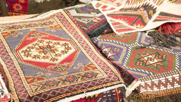 Pile of beautiful handmade carpets on the open market bazaar. Turkish traditional design.