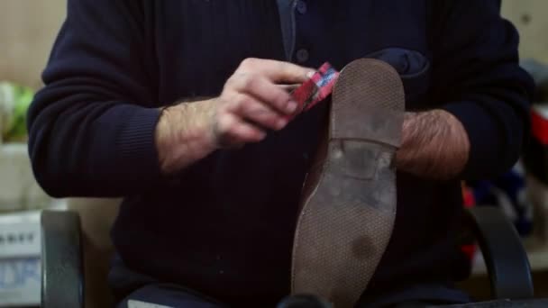 Shoemaker cleaning shoe with sponge at cobbler workshop. Close up view. — Stock Video