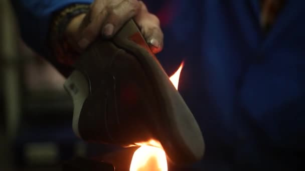 Schuhmacher, der Schuhe macht. Arbeit mit Feuer in der Schusterwerkstatt. Zeitlupe. — Stockvideo