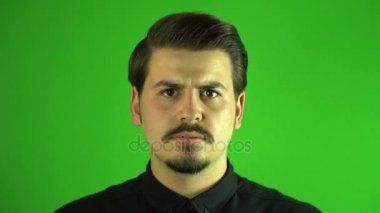 Ağır çekim kızgın genç adam kameraya çığlık. GreenBox arka plan.