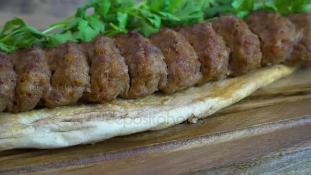 Vynikající tradiční turecké a arabské ramadánu Kofta horké maso. Adana kebab je dlouhé, plné ruce mleté maso kebab namontované na široké železné špíz a grilované na otevřený mangal hořící uhlí. Rotační záběr. — Stock video