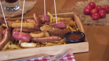 Sosis, soğan, kızarmış tavuk, schnitzel ve patates kızartması. Kızarmış fast food yemek kova ile dolu. Geleneksel bira aperatif. Yakın çekim, atış pan. 