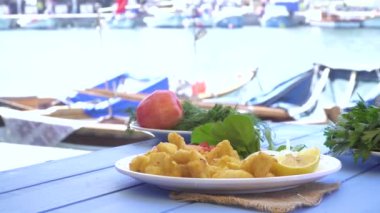 Kızarmış deniz limon ve roka mavi tablo tarafından küçük bir kasaba, küçük tekneler ve deniz ürünleri. Izmir Foça Türkiye.