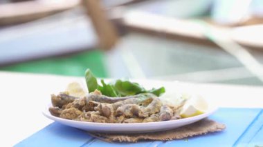 Limon ve roka mavi masada Türk kırmızı Tava. Fried hamsi Foça Izmir denizde tarafından. Deniz ve küçük tekne arka plan kopya alanı.